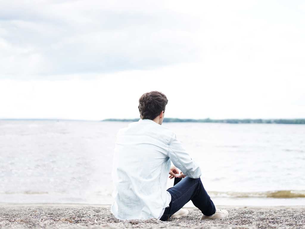 A man sitting on a shore